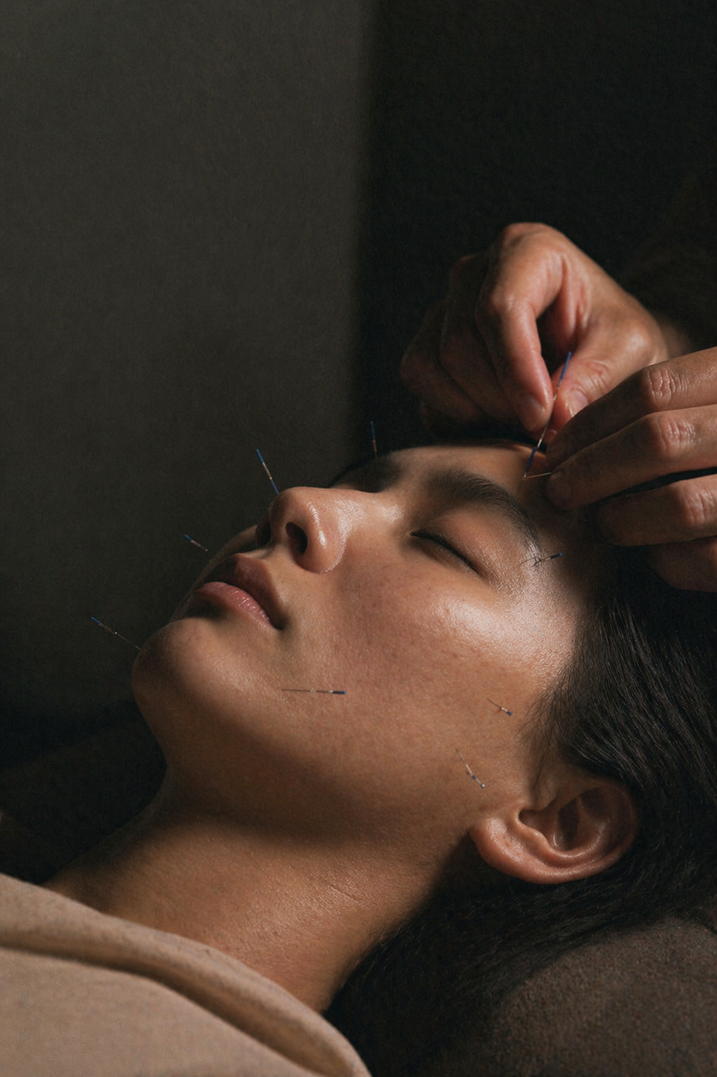 Person receiving a facial treatment with needles on a dark background
