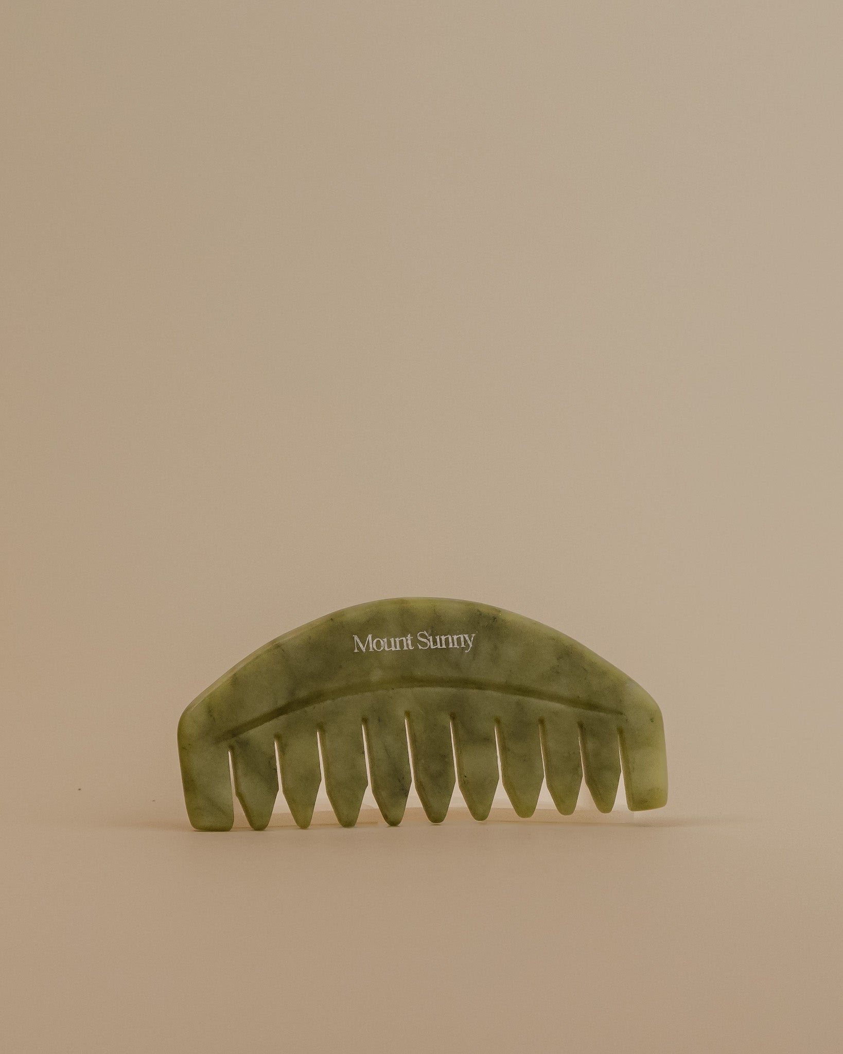 Green comb with 'Mount Sunny' branding on a beige background