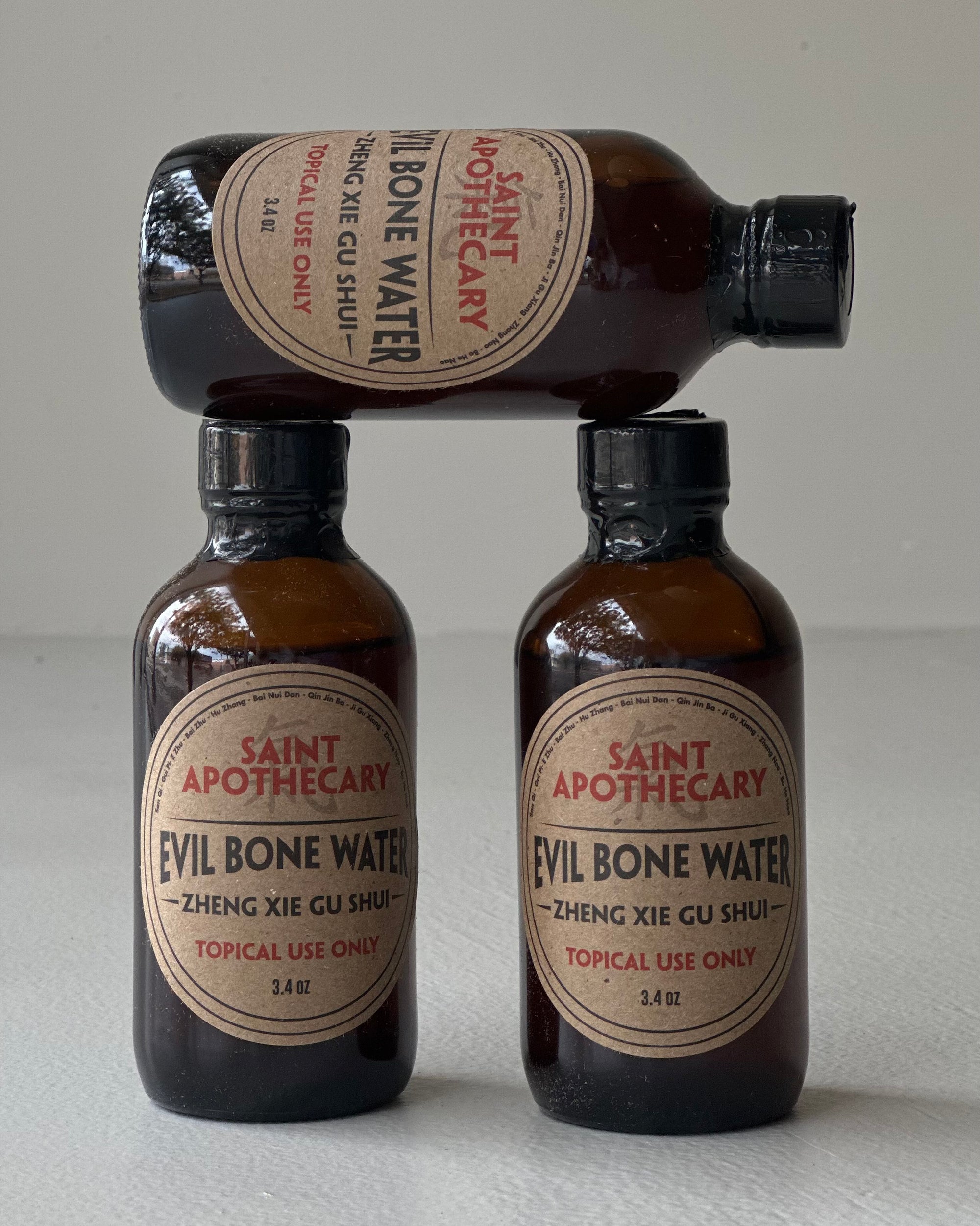 Three bottles of Evil Bone Water from Saint Apothecary, a traditional Chinese medicinal product for pain relief and healing